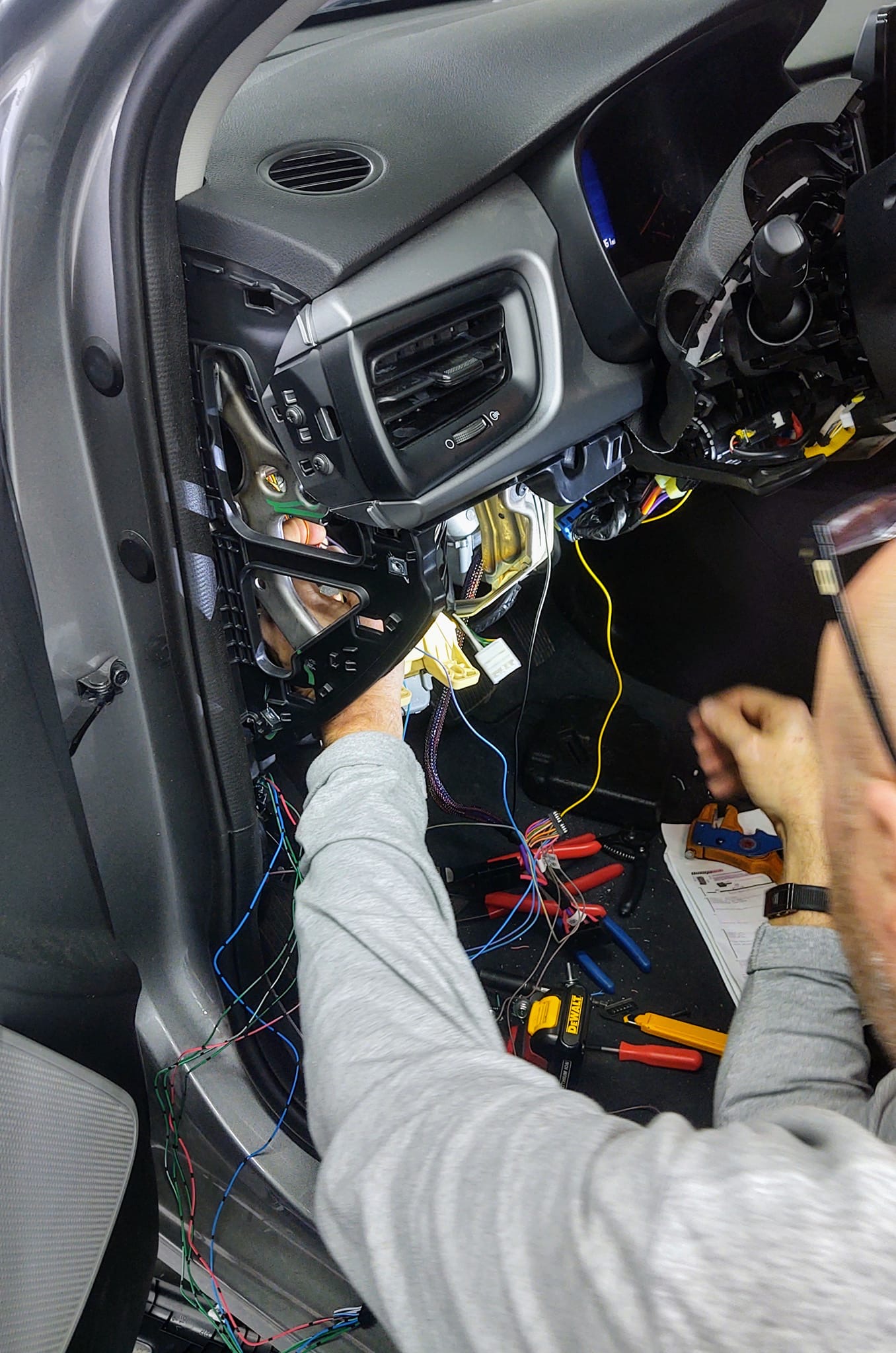 Dashboard torn apart with wiring harness exposed during car audio and remote start installation